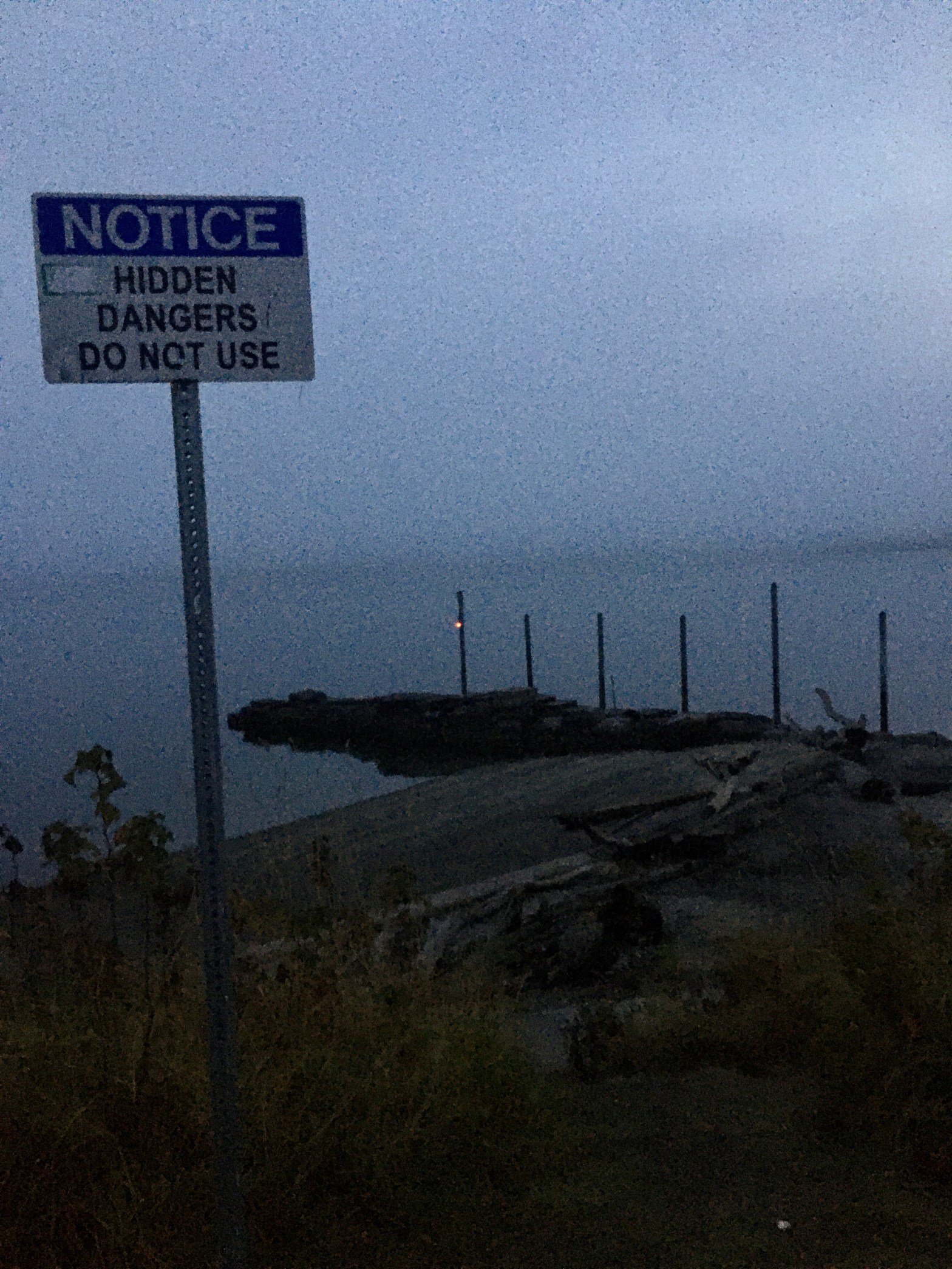 An old boat ramp at Title Park with a sign that reads "NOTICE HIDDEN DANGERS DO NOT USE."
